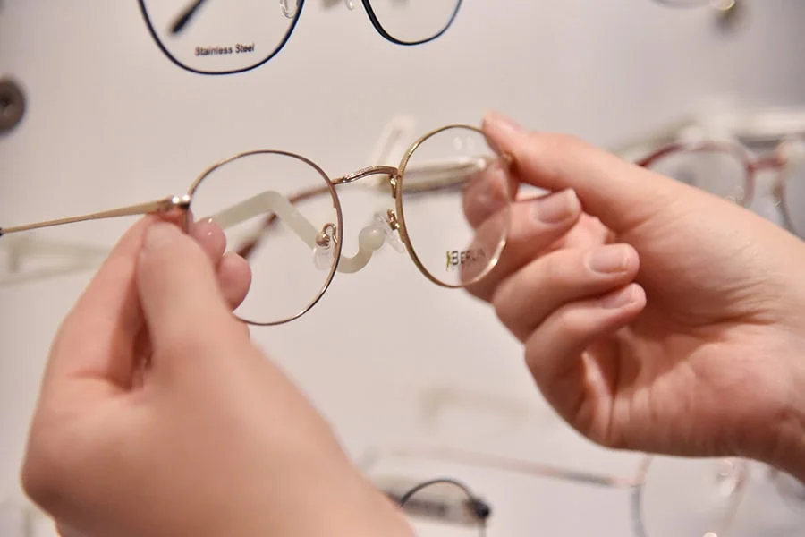sehen-2 Optikerin hält BERLIN Brille in der Hand